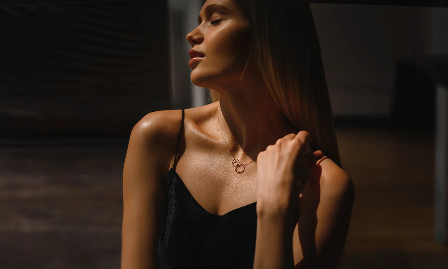 A graceful woman in a dark satin dress, highlighted by dramatic lighting, exuding elegance and poise - Kybella in West Hollywood, CA